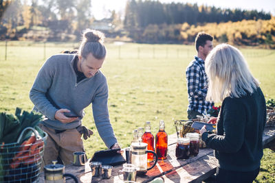 Farmers using technologies with food displayed for sale on table