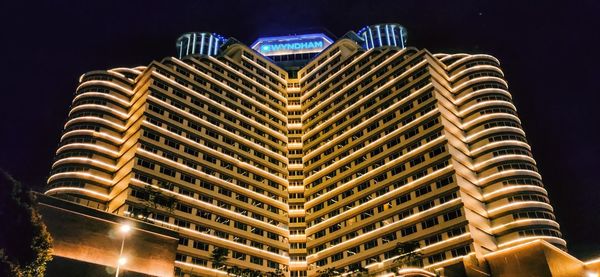 Low angle view of illuminated building against sky at night