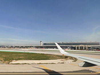 Airplane on airport runway against sky