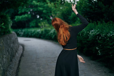 Rear view of woman dancing on street