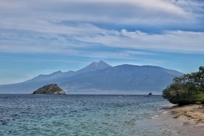 Scenic view of sea and mountains against sky