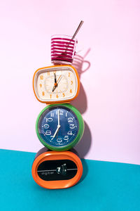 Close-up of clock on table against wall