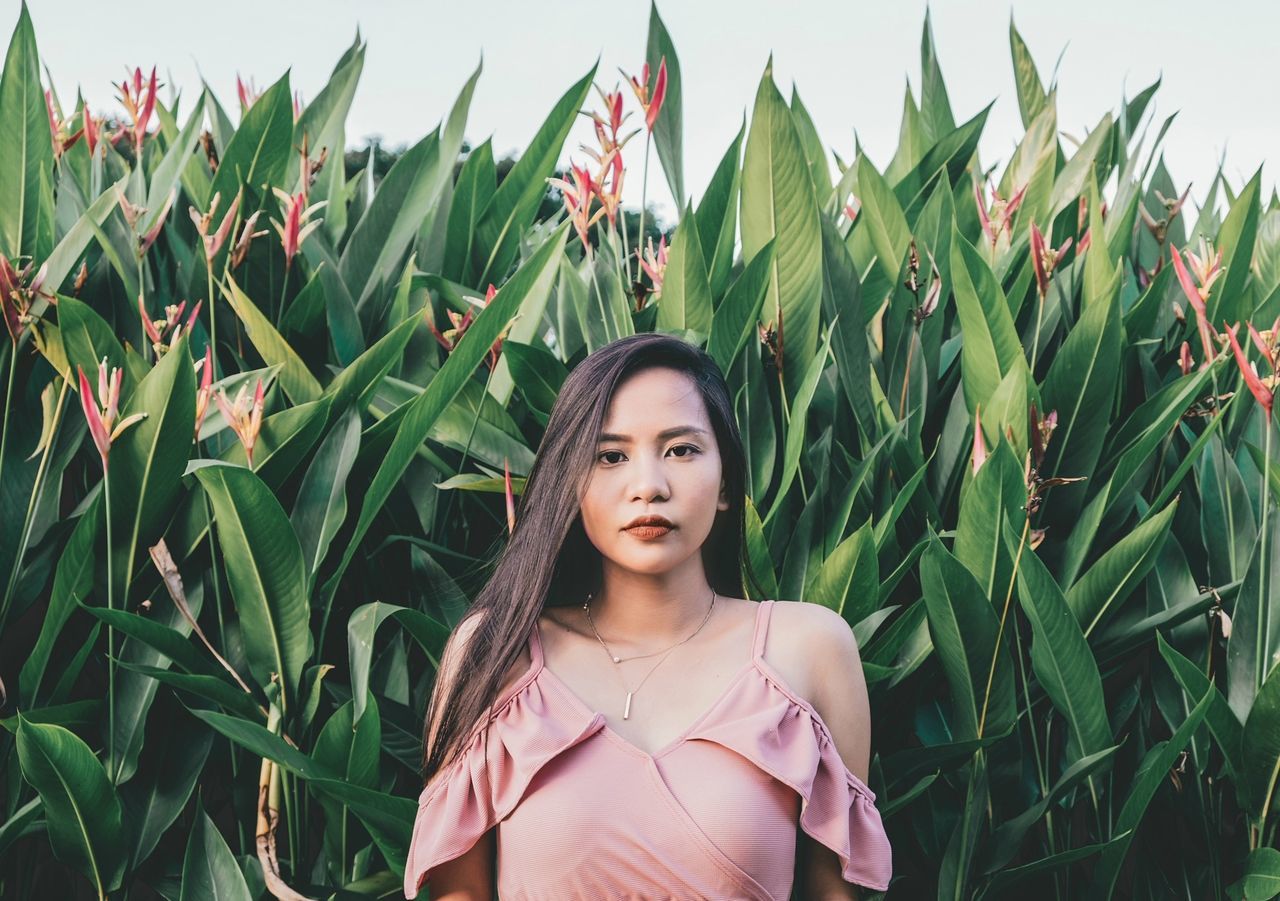 plant, one person, growth, looking at camera, young adult, young women, portrait, standing, real people, front view, leisure activity, women, land, lifestyles, nature, green color, field, day, beautiful woman, outdoors, hairstyle