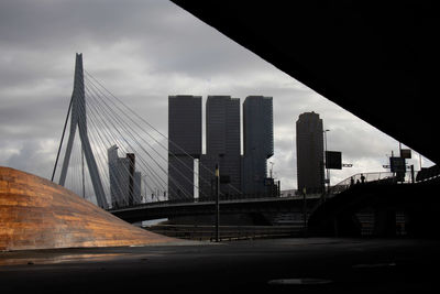 Bridge by buildings in city against sky
