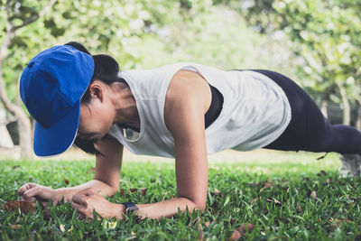 Mid adult woman exercising on grassy field