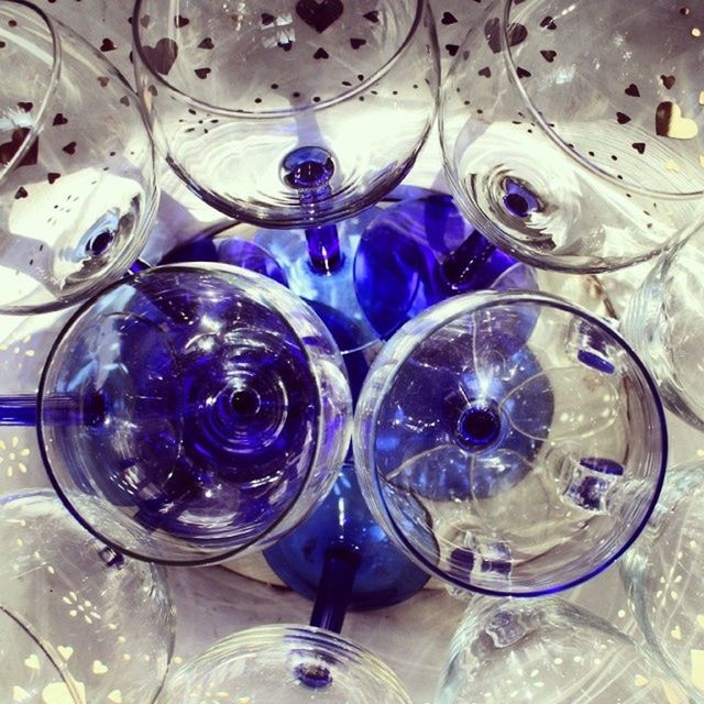 indoors, glass - material, transparent, still life, drinking glass, close-up, table, reflection, blue, multi colored, glass, pattern, large group of objects, variation, high angle view, no people, bottle, abundance, arrangement, water