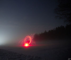 Light trails on field against sky at night