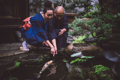 Man with fish in water at park