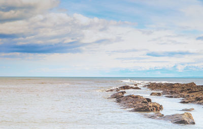 Scenic view of calm sea against cloudy sky