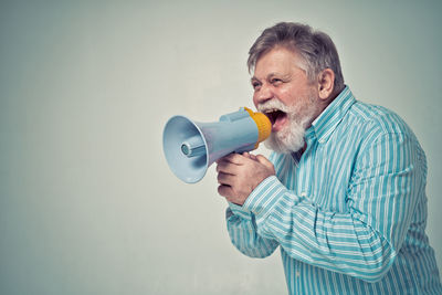 Reflection of man photographing against white background