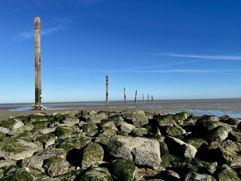 Panoramic view of rocks on beach against blue sky