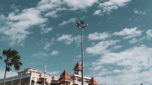 Low angle view of street light by building against sky