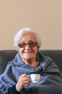 Portrait of a very elderly woman drinking coffee. positive ninety year old grandmother