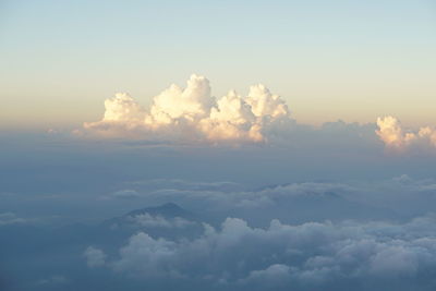 Low angle view of sunlight streaming through clouds