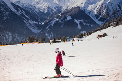 People skiing on snow covered against mountain