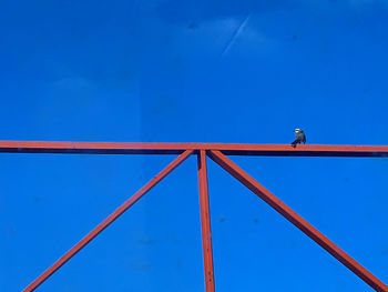 Low angle view of crane against clear blue sky