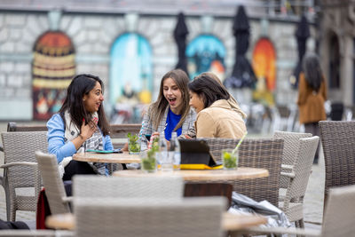 Friends using mobile phone at restaurant