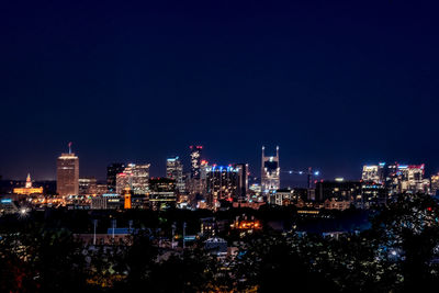 Illuminated buildings in city against sky at night