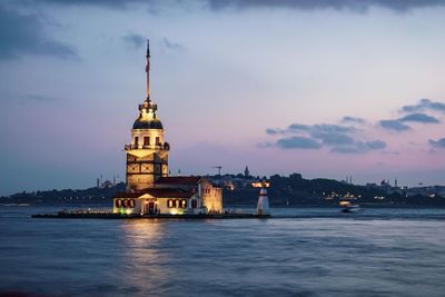 Historic building by sea against sky during dusk