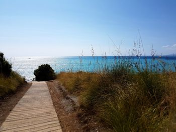 Footpath by sea against sky