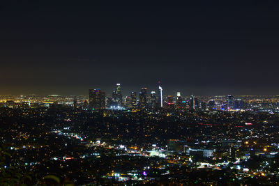 Illuminated cityscape against sky at night