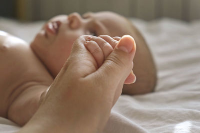 Low section of baby on bed at home