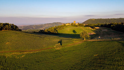 Aerial view from the drone of hills, italy, during sunset, with countryside road and meadows