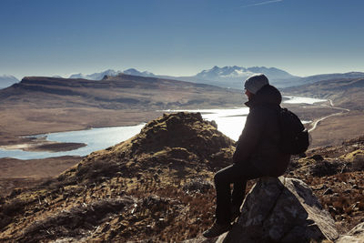 Man looking at mountain against sky