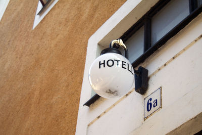 Low angle view of hotel sign on wall