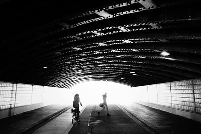 Full length of woman walking in tunnel