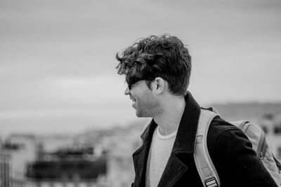 Side view of smiling man with shoulder bag