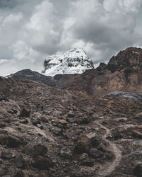 Low angle view of snowcapped mountain against cloudy sky