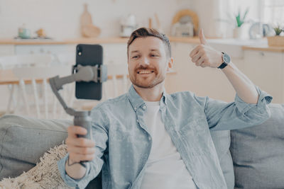 Man gesturing while vlogging over mobile phone