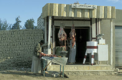 Rear view of woman sitting on street