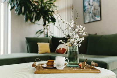 Home interior. cookies, coffee. apple tree color has flown, bird. blurred background