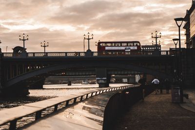 Train on bridge in city against sky