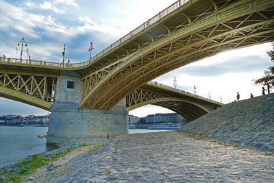 Bridge over river against cloudy sky