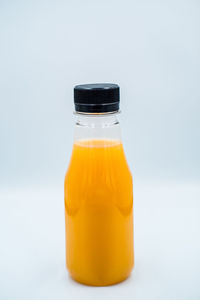 Close-up of orange bottle against white background