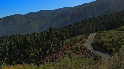 Scenic view of road by mountains against sky