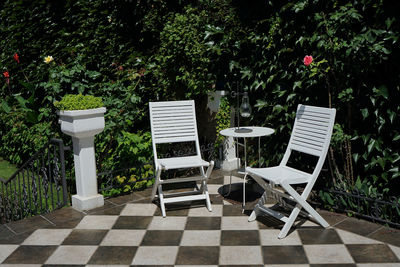 Two white chairs and table on the terrace in the house yard