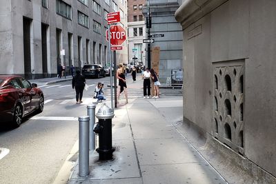 People walking on street amidst buildings in city