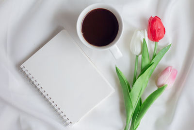 High angle view of tulip and book on table