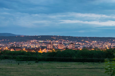 Illuminated buildings in city against sky