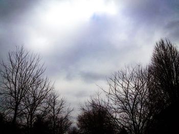 Low angle view of bare tree against cloudy sky