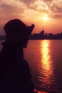 Woman looking at view of city during sunset