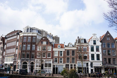 Low angle view of buildings against cloudy sky