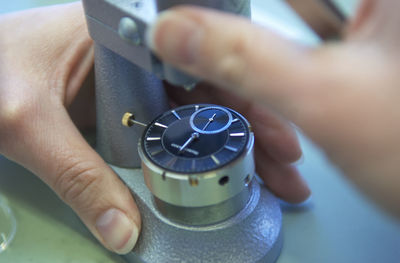 Close-up of hands working on wristwatch