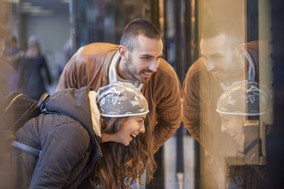 Midsection of couple looking at shop window