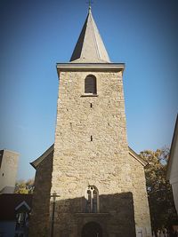 Low angle view of bell tower against clear blue sky