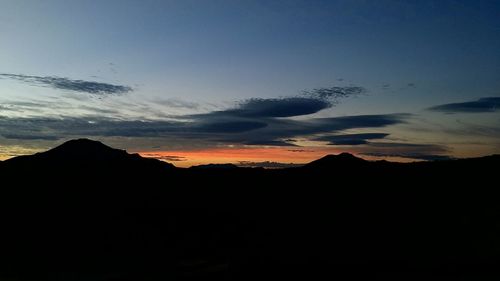 Silhouette landscape against sky at sunset